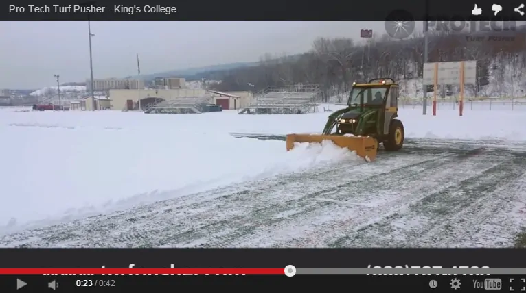 Turf Pusher Clearing Snow on Field